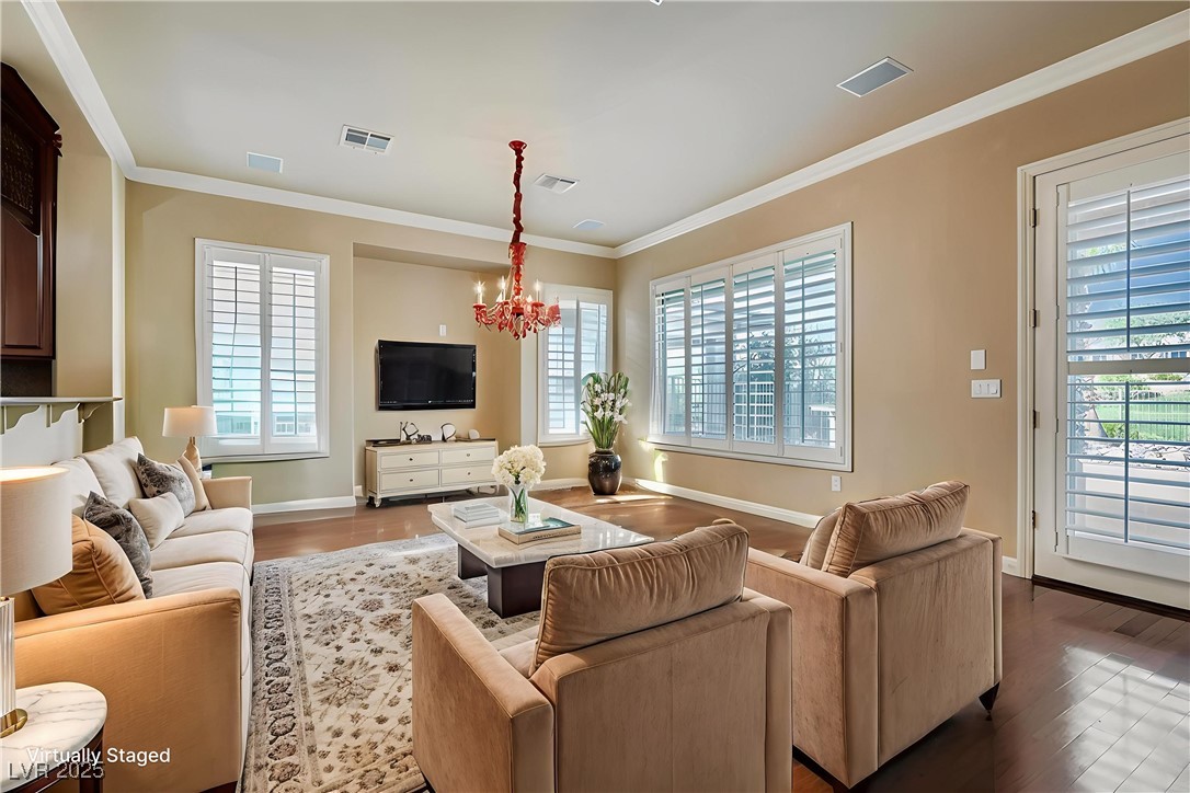 5015 Rivedro Street Las Vegas, NV 89135 - Photo 5 of 63 Virtually Staged- Enjoy a seamless transition into a spacious open area—perfect for formal dining and/or a cozy family room. Ornamental molding and light wood-style flooring add warmth and sophistication to this flexible living space.