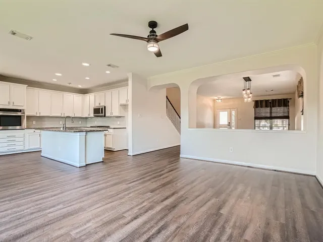 a view of a kitchen with cabinets stainless steel appliances and wooden floor