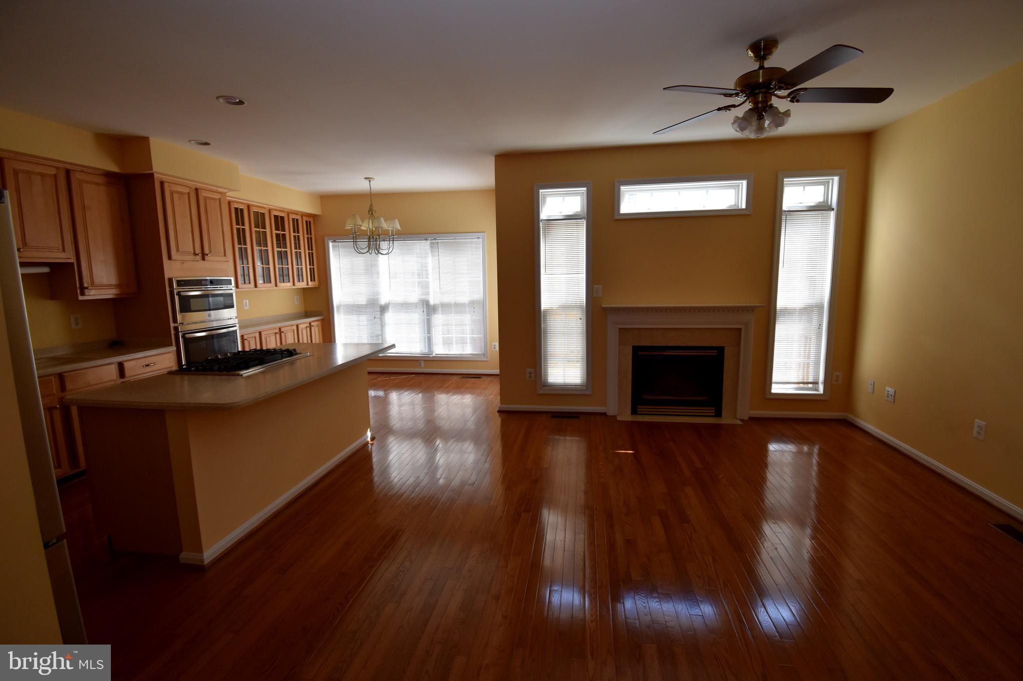 13571 Cedar Run Lane Herndon, VA 20171 - Photo 33 of 33 a kitchen with granite countertop wooden floors a fireplace and a chandelier