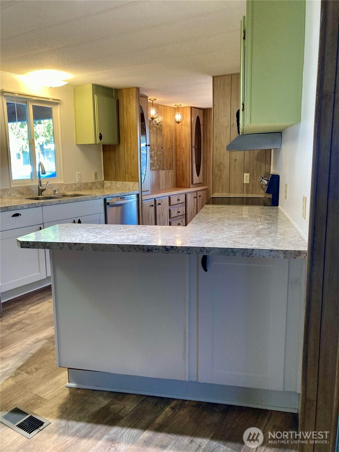 1841 Trosper Road Southwest, Unit 32 Tumwater, WA 98512 - Photo 4 of 13 a kitchen with kitchen island granite countertop a sink cabinets and stainless steel appliances