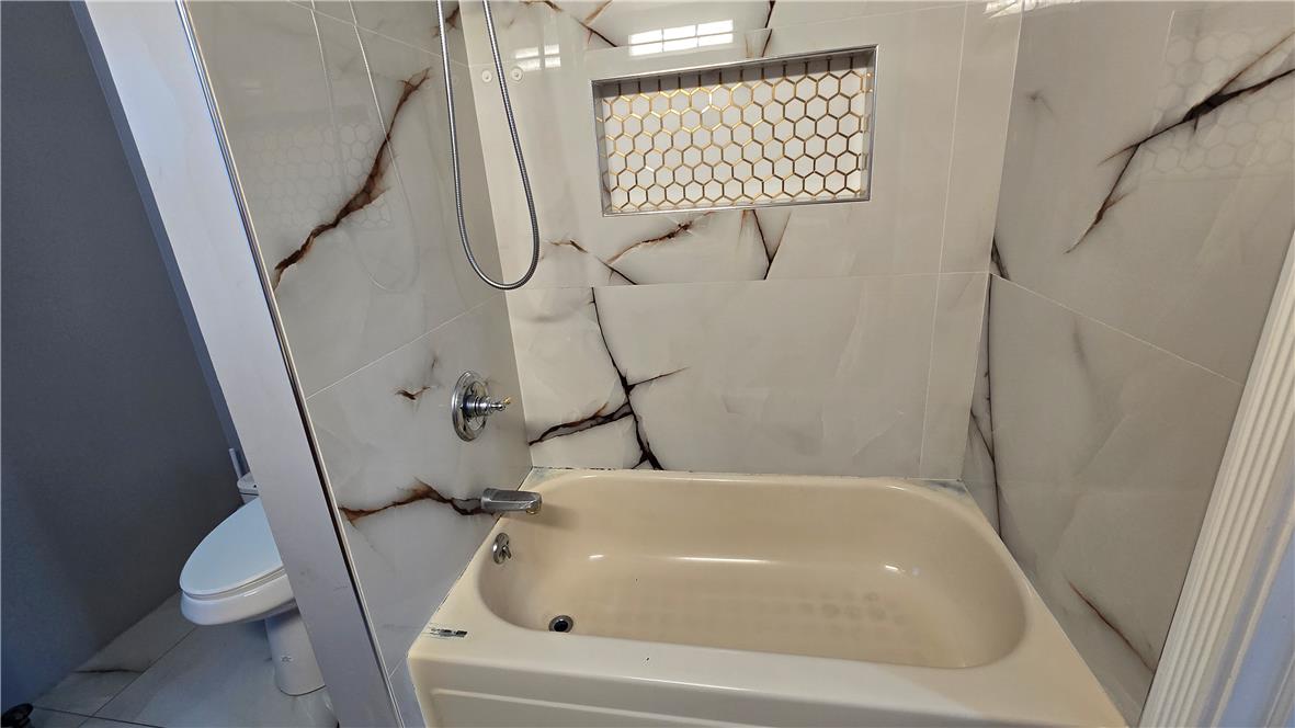 883 North Locust Street Hazleton, PA 18201 - Photo 51 of 83 A deep soaking tub with elegant tile surrounds and convenient built-in shelving.