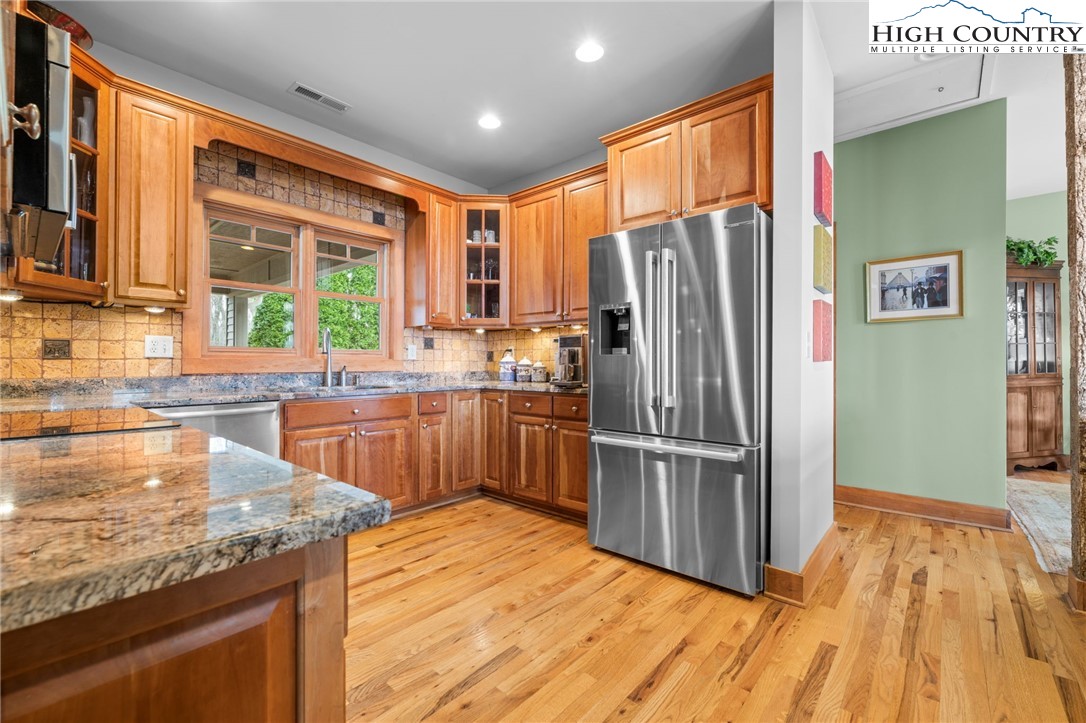 1690 Evergreen Drive Boone, NC 28607 - Photo 15 of 47 a kitchen with stainless steel appliances granite countertop a refrigerator a sink dishwasher a stove and a dining table with wooden floor