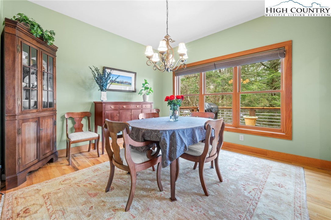 1690 Evergreen Drive Boone, NC 28607 - Photo 18 of 47 a dining room with furniture a rug a flat screen tv and a chandelier