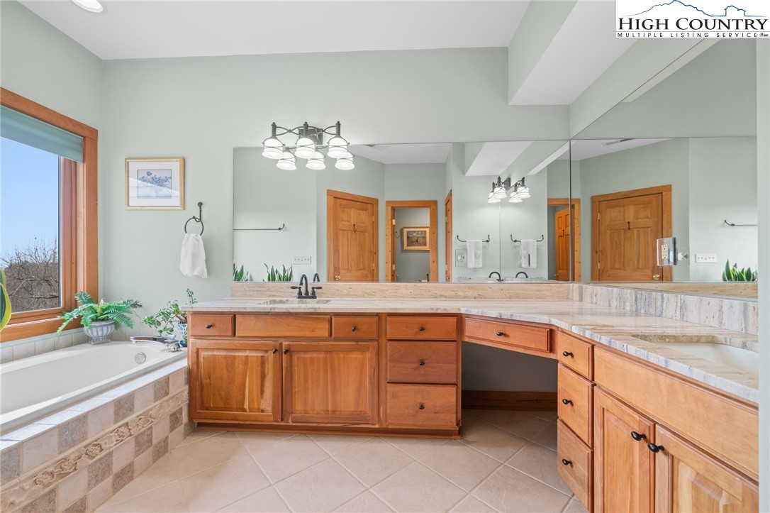 1690 Evergreen Drive Boone, NC 28607 - Photo 31 of 47 a spacious bathroom with a granite countertop sink and a large mirror