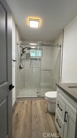 a bathroom with a granite countertop toilet a sink a mirror and shower