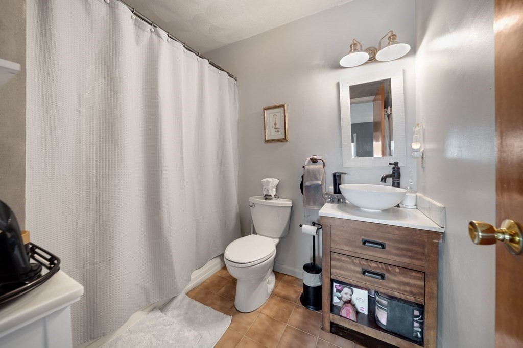 80 Ridge Road, Unit 80 Revere, MA 02151 - Photo 28 of 41 a bathroom with a granite countertop sink toilet and a mirror