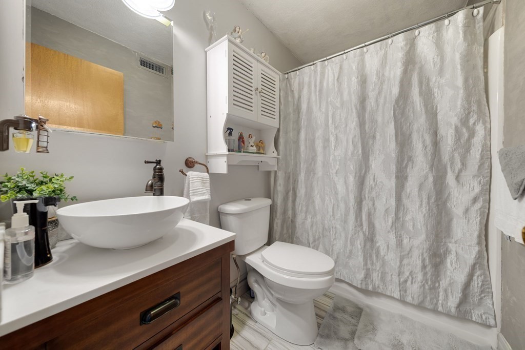 80 Ridge Road, Unit 80 Revere, MA 02151 - Photo 30 of 41 a bathroom with a sink a toilet a mirror and vanity