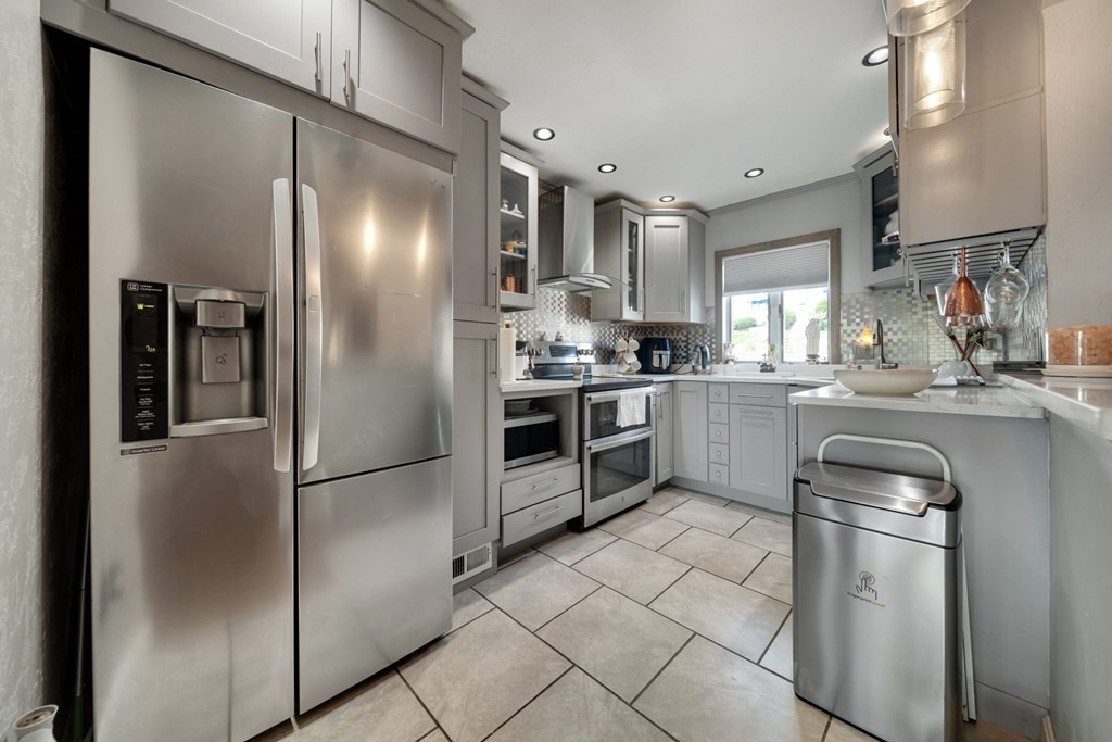 80 Ridge Road, Unit 80 Revere, MA 02151 - Photo 9 of 41 a kitchen with stainless steel appliances granite countertop a refrigerator a sink a stove and white cabinets