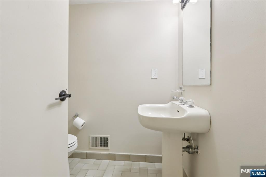 5 Millay Court Teaneck, NJ 07666 - Photo 14 of 36 a bathroom with a sink a toilet and mirror