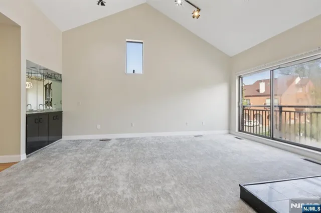 a view of an empty room with staircase and a window