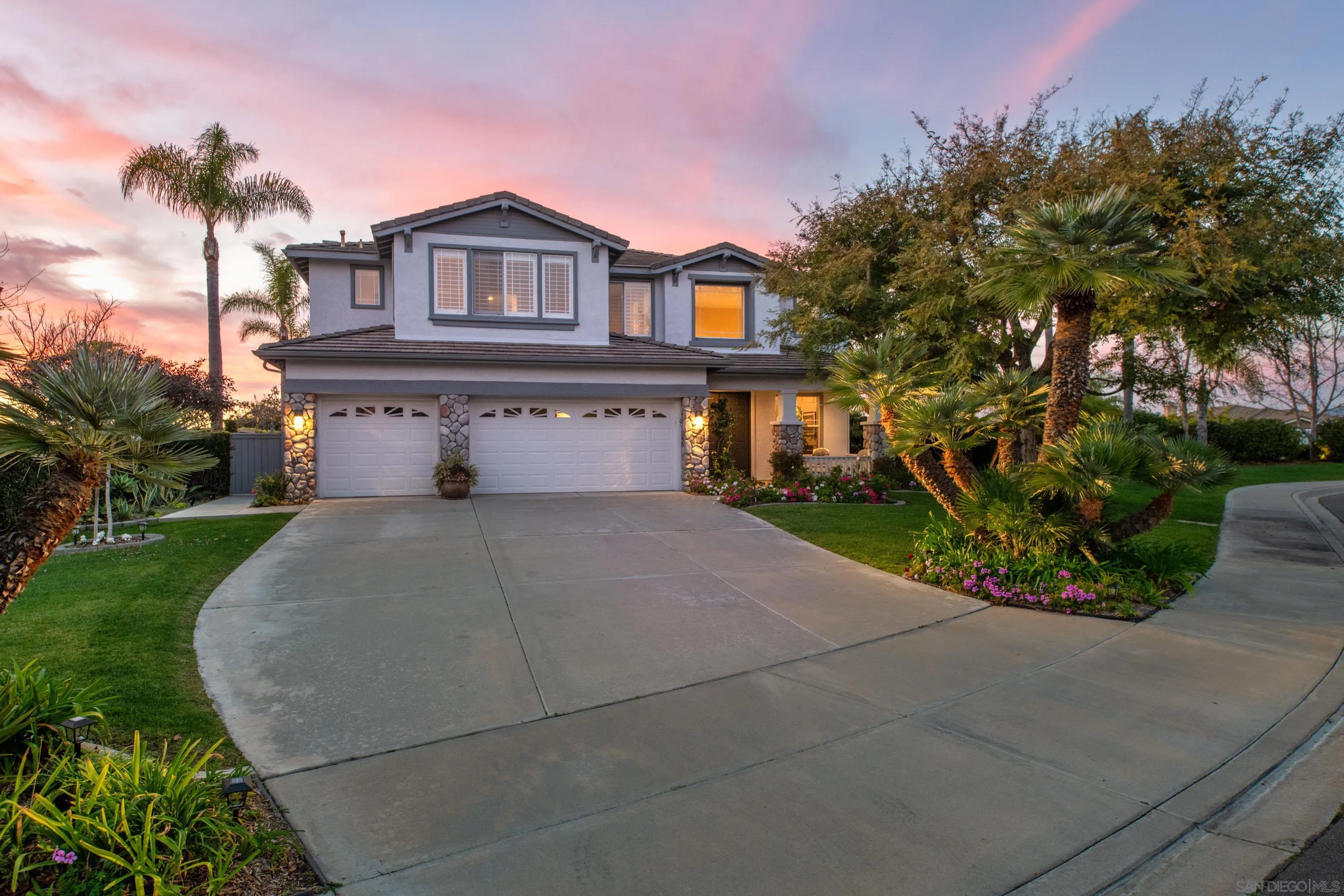 a front view of a house with a yard and trees