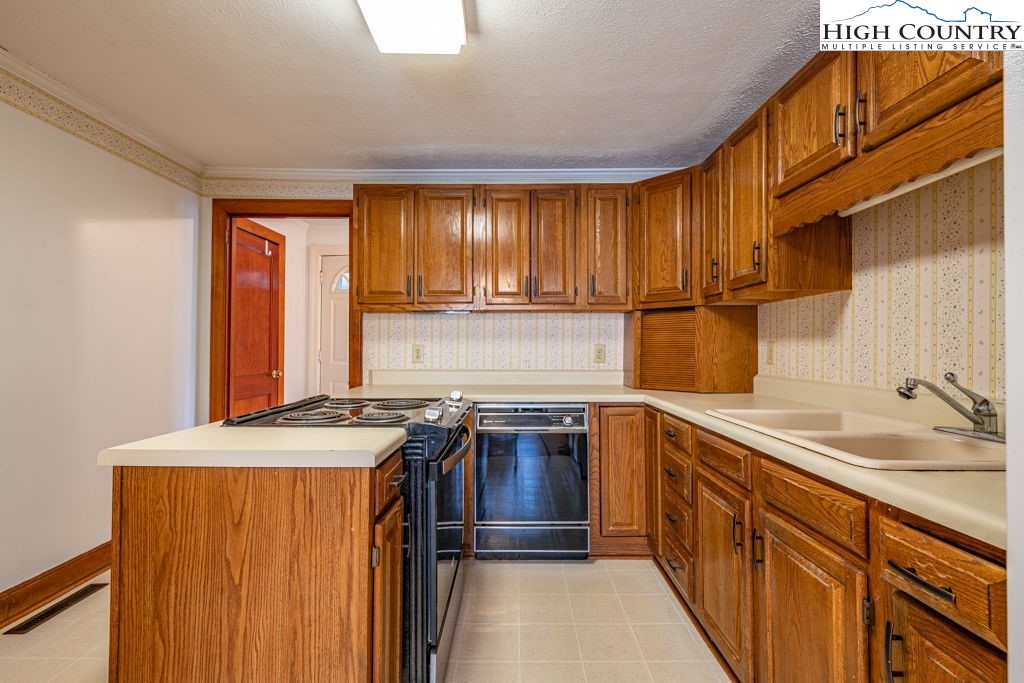 268 Farthing Street Boone, NC 28607 - Photo 13 of 30 a kitchen with stainless steel appliances granite countertop a sink stove and cabinets