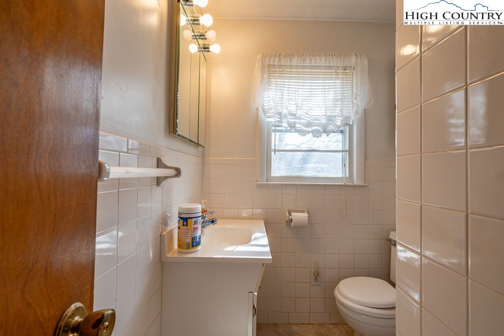 268 Farthing Street Boone, NC 28607 - Photo 19 of 30 a bathroom with a granite countertop toilet sink and mirror