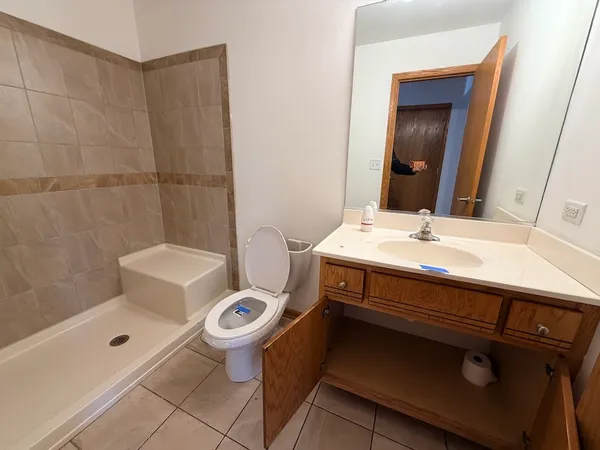 a bathroom with a sink a toilet and shower