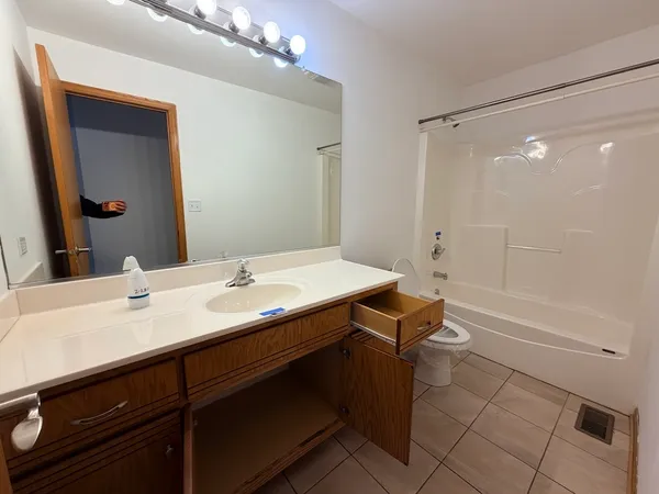 a bathroom with a sink a toilet a mirror and shower