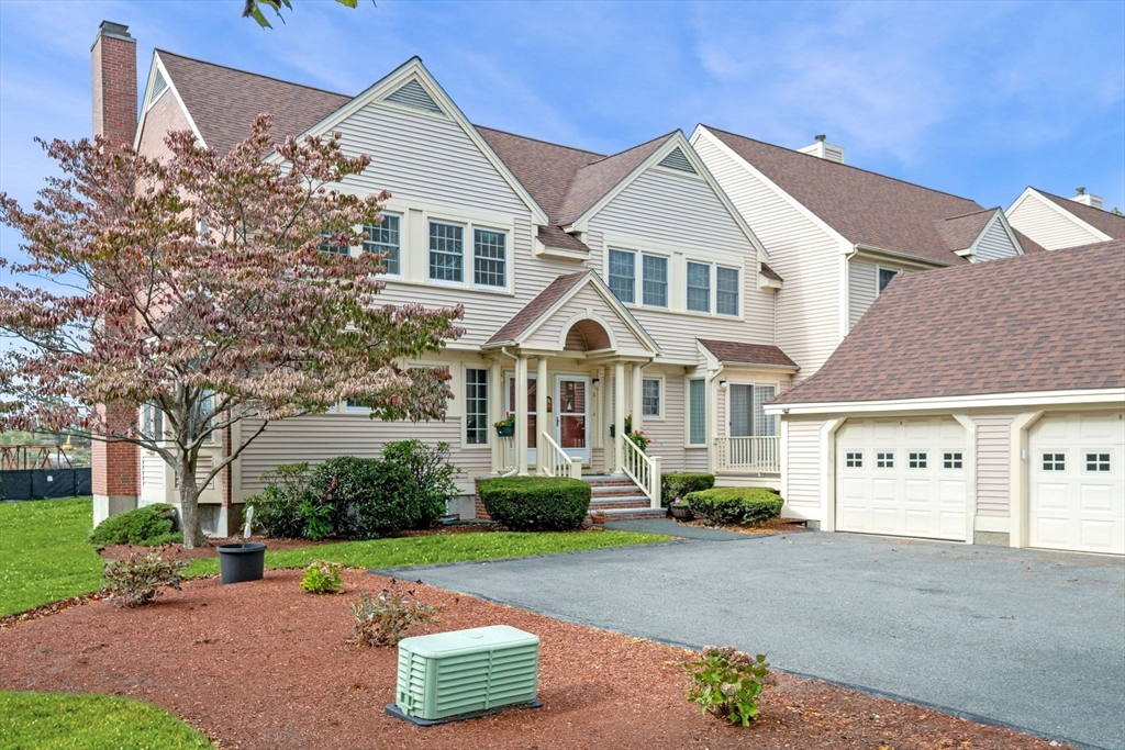 33 Water Street, Unit 7 Danvers, MA 01923 - Photo 2 of 35 a front view of a house with a yard and garage