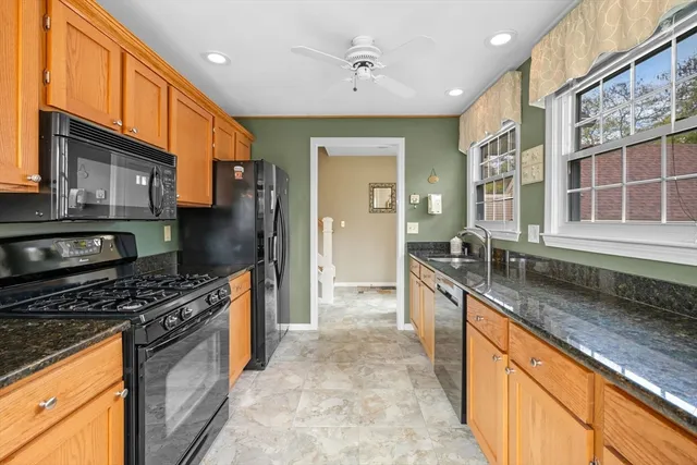 a large kitchen with stainless steel appliances granite countertop a stove and a sink