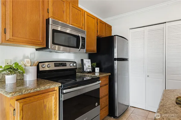 a kitchen with stainless steel appliances granite countertop a stove a sink and a microwave