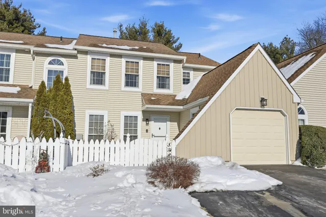a view of a house with a small yard and wooden floor and fence
