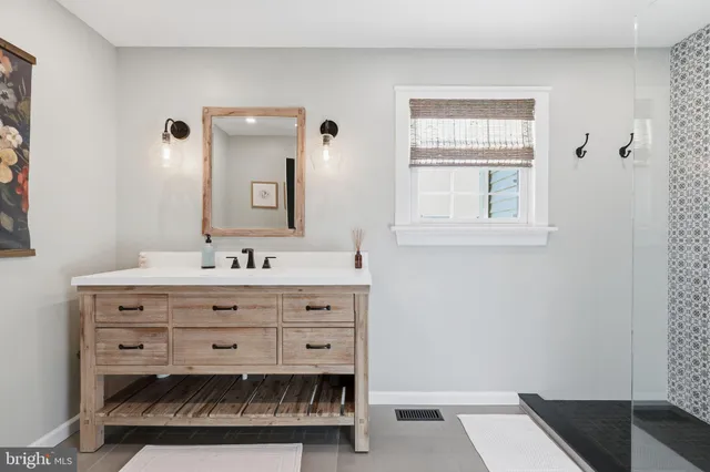 a bathroom with a sink vanity and mirror