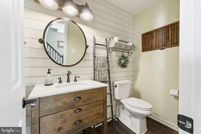 a bathroom with a toilet sink vanity and mirror