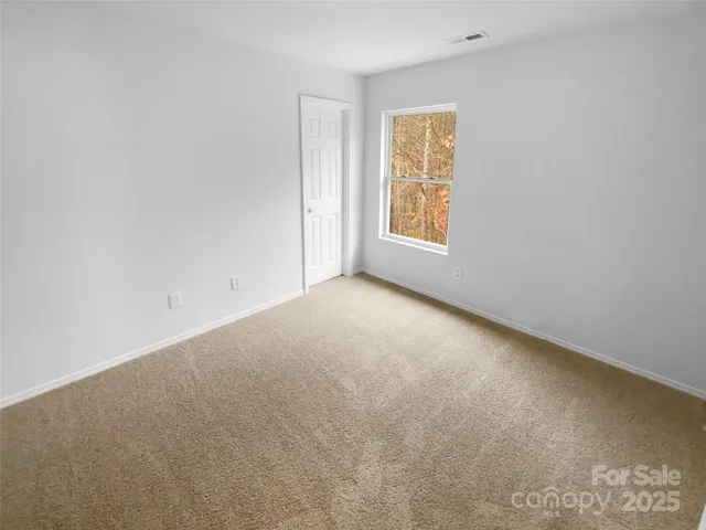 an empty room with windows and chandelier fan