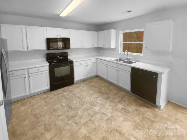 a kitchen with granite countertop a sink stove and microwave
