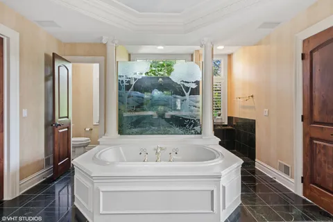 a white bath tub sitting in a en suite bathroom