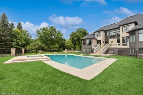 a view of a house with pool and a yard