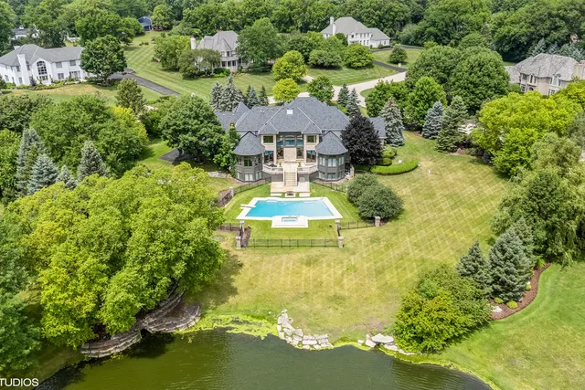 a aerial view of a house with swimming pool outdoor seating and yard