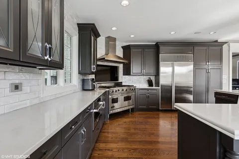 a kitchen with kitchen island granite countertop a sink cabinets and stainless steel appliances