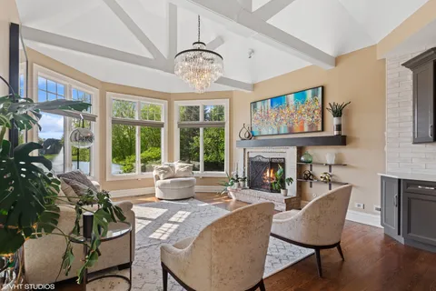 a living room with furniture a fireplace and a large window