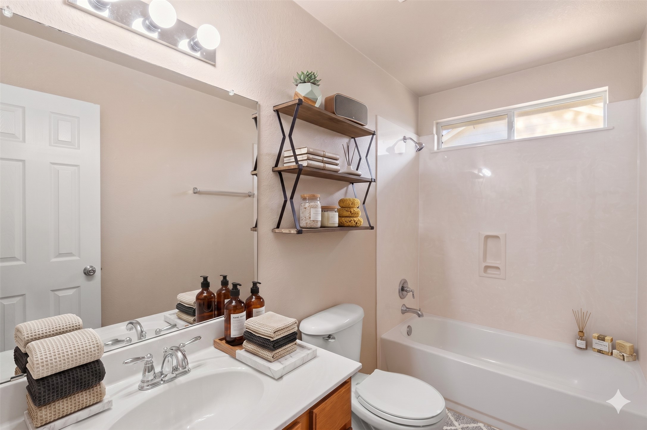 20224 Merlin Falcon Trail Pflugerville, TX 78660 - Photo 8 of 40 A well-lit primary bathroom features a bathtub and a vanity with an expansive mirror and shelving.