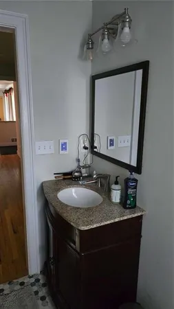 a bathroom with a granite countertop sink a mirror and vanity