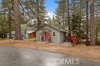 a view of a house with a yard and large tree