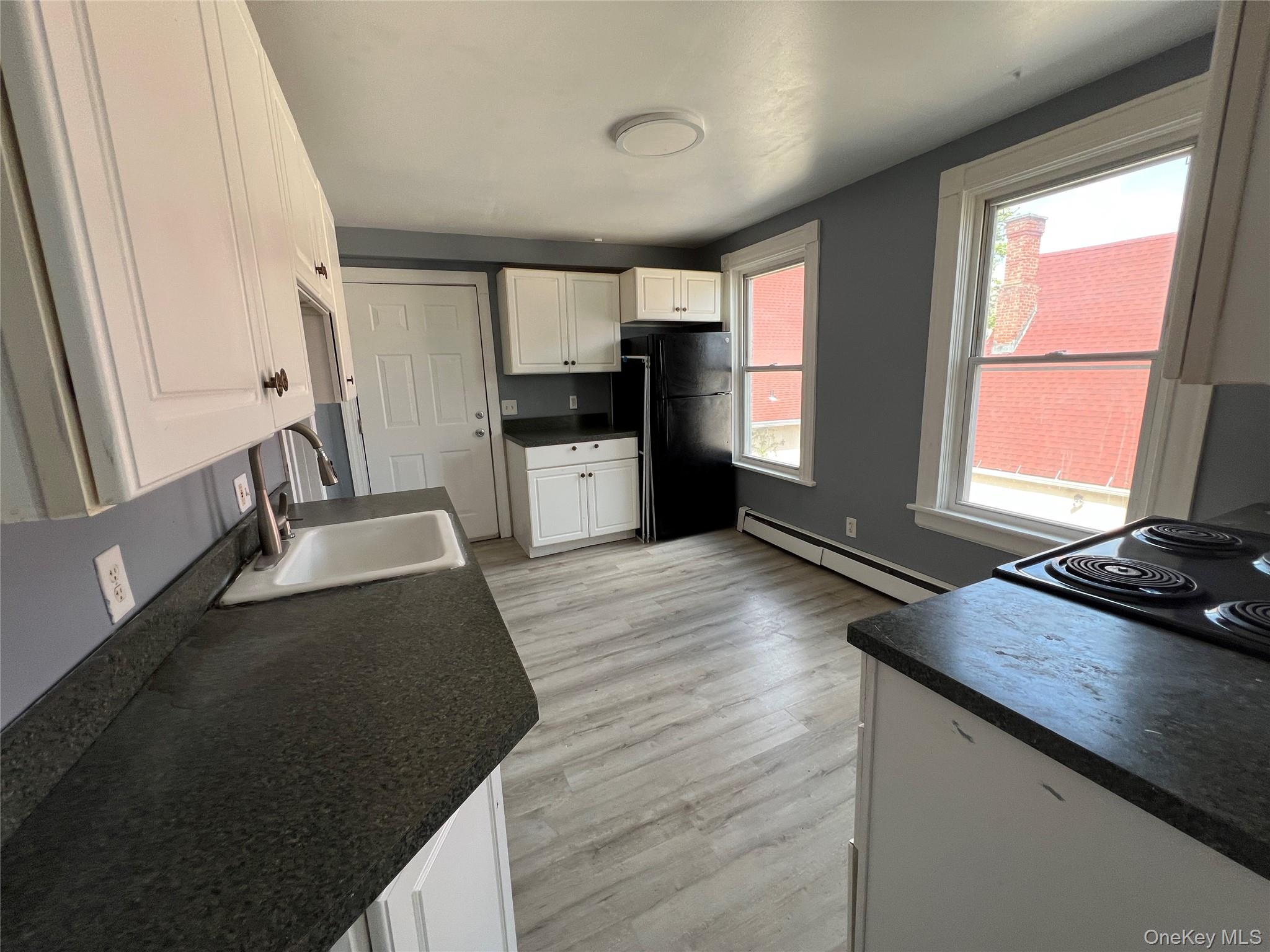 761 Main Street, Unit 3E Poughkeepsie, NY 12603 - Photo 3 of 8 a kitchen with granite countertop a sink stove and refrigerator