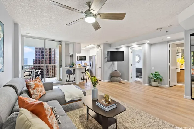 a living room with furniture a flat screen tv and a large window