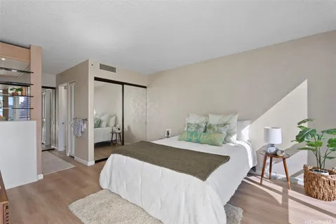 a bedroom with a bed and potted plant