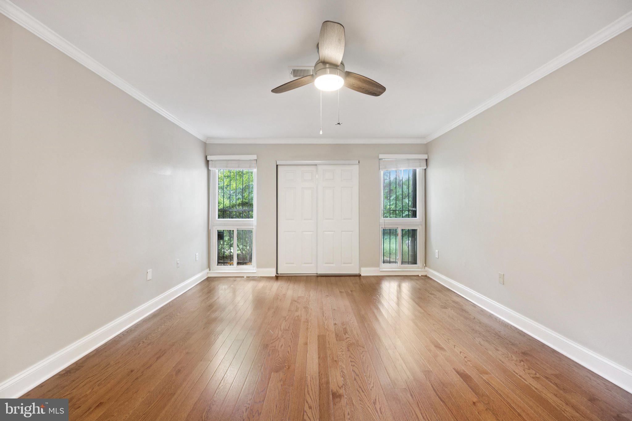 2016 Coleridge Drive, Unit 24102 Silver Spring, MD 20902 - Photo 11 of 19 a view of an empty room with wooden floor and a window