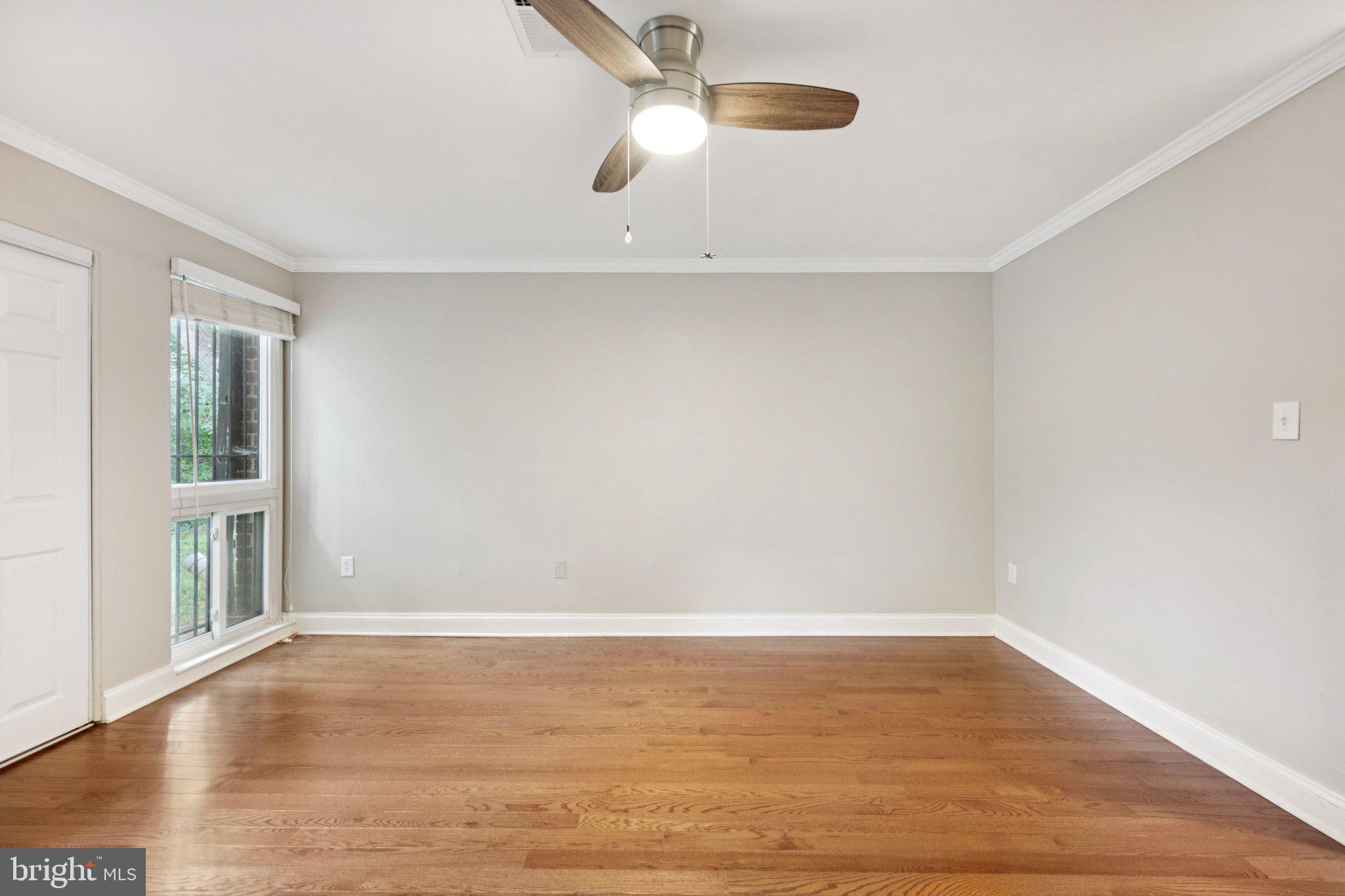 2016 Coleridge Drive, Unit 24102 Silver Spring, MD 20902 - Photo 15 of 19 wooden floor in an empty room with a window