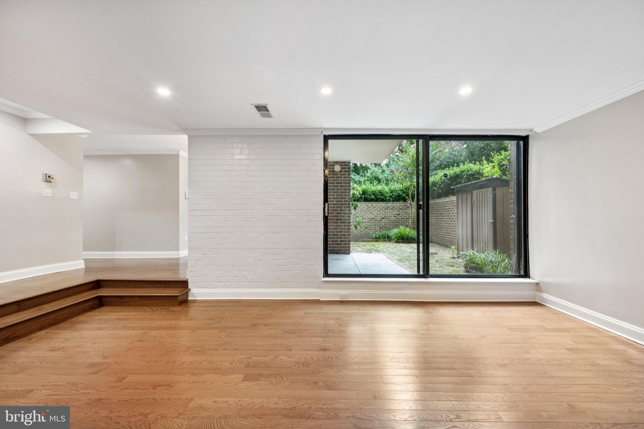 2016 Coleridge Drive, Unit 24102 Silver Spring, MD 20902 - Photo 4 of 19 an empty room with wooden floor and a window