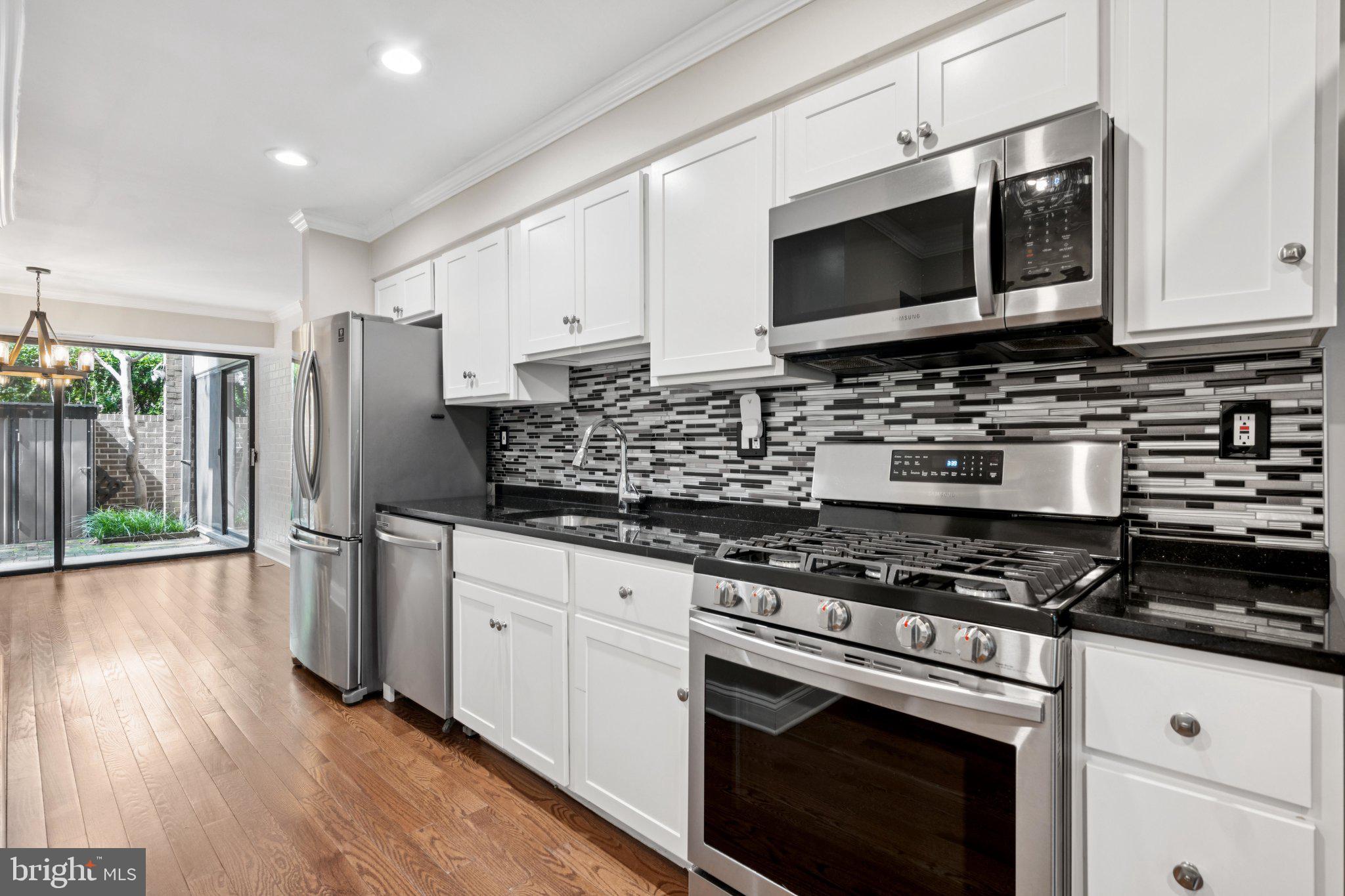 2016 Coleridge Drive, Unit 24102 Silver Spring, MD 20902 - Photo 8 of 19 a kitchen with stainless steel appliances granite countertop a stove a sink and a microwave