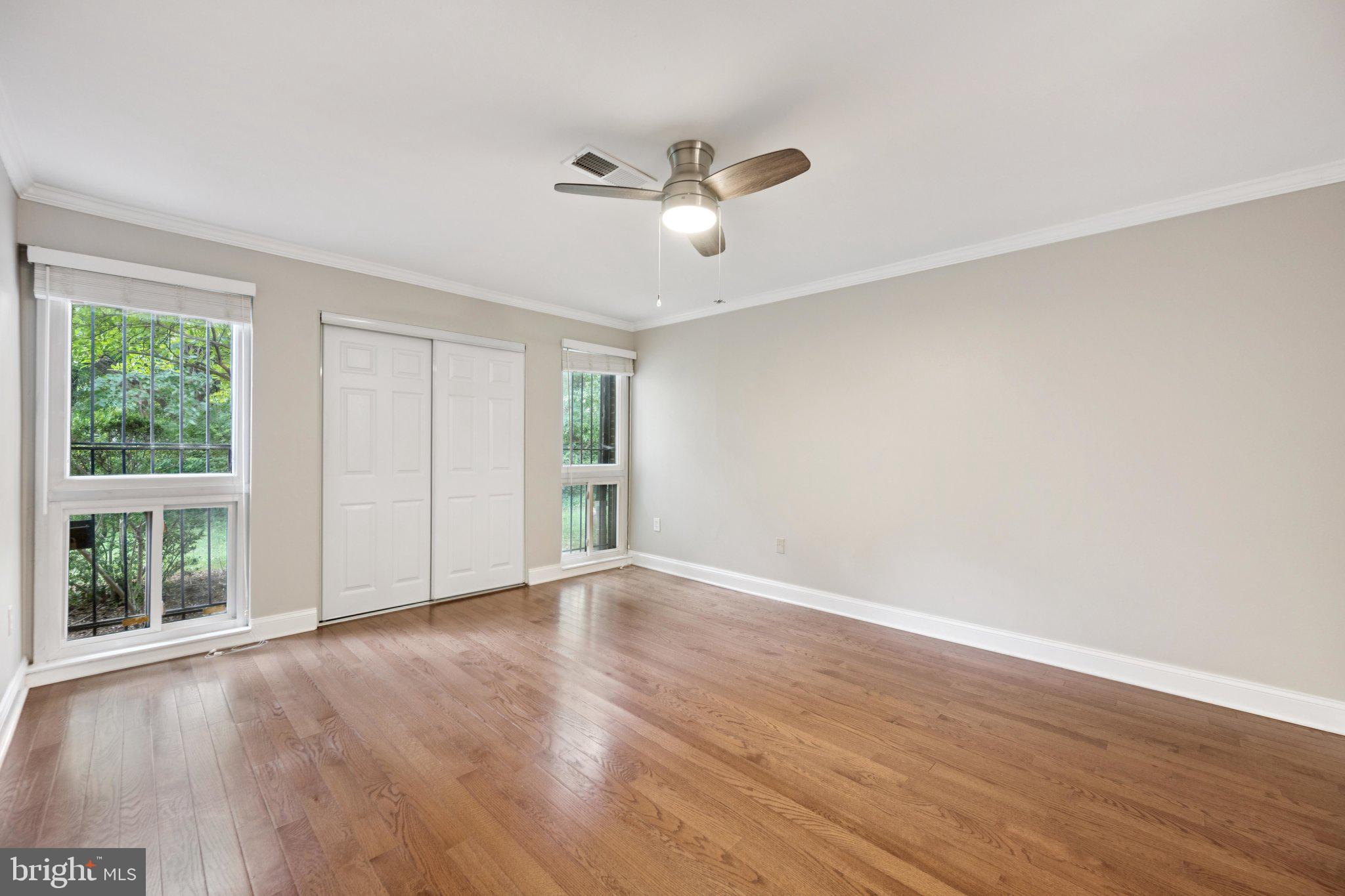 2016 Coleridge Drive, Unit 24102 Silver Spring, MD 20902 - Photo 10 of 19 a view of an empty room with wooden floor and a window
