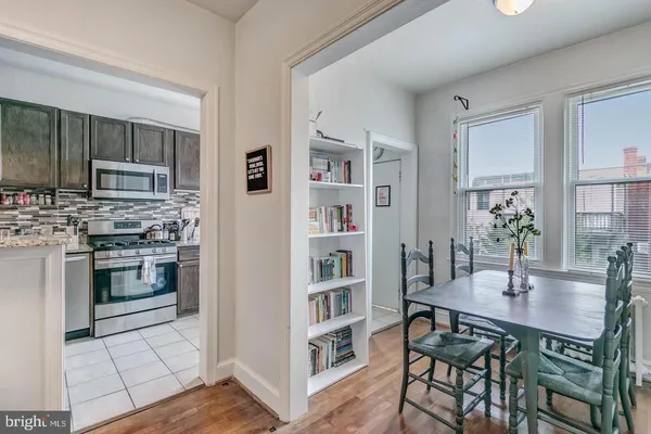 a kitchen with a table chairs stainless steel appliances and cabinets