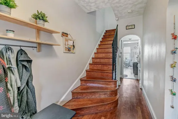 a view of a hallway with wooden floor and stairs