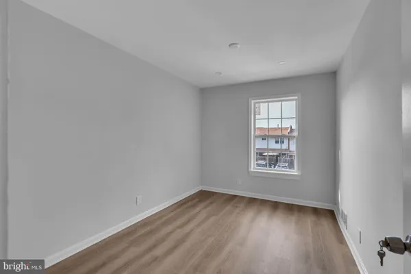 an empty room with wooden floor and window