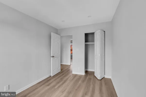 a view of an empty room with closet and a window