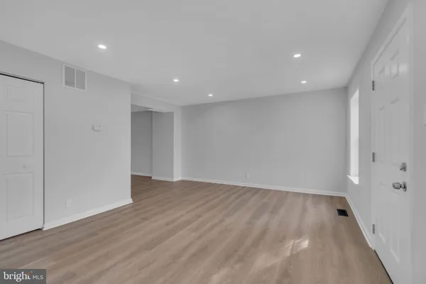 a view of an empty room with wooden floor