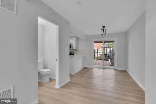 a view of a hallway with wooden floor and a living room