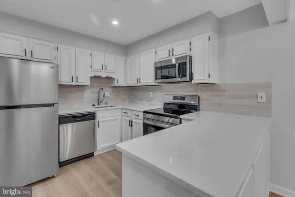 a kitchen with stainless steel appliances granite countertop white refrigerator sink stove and microwave